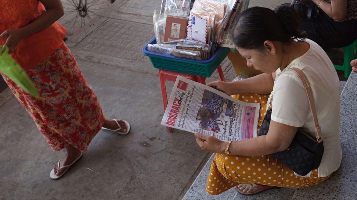 Kvinnelig avisleser i Myanmar