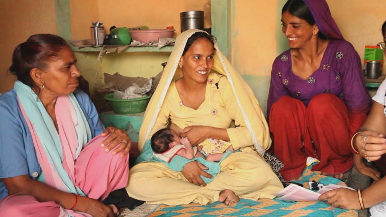 Nybakt mor Sakunat Mubin (gult) med datteren Esana, til venstre asha Sudesh Kumari til venstre. Bilde fra filmopptak i India 2013. 