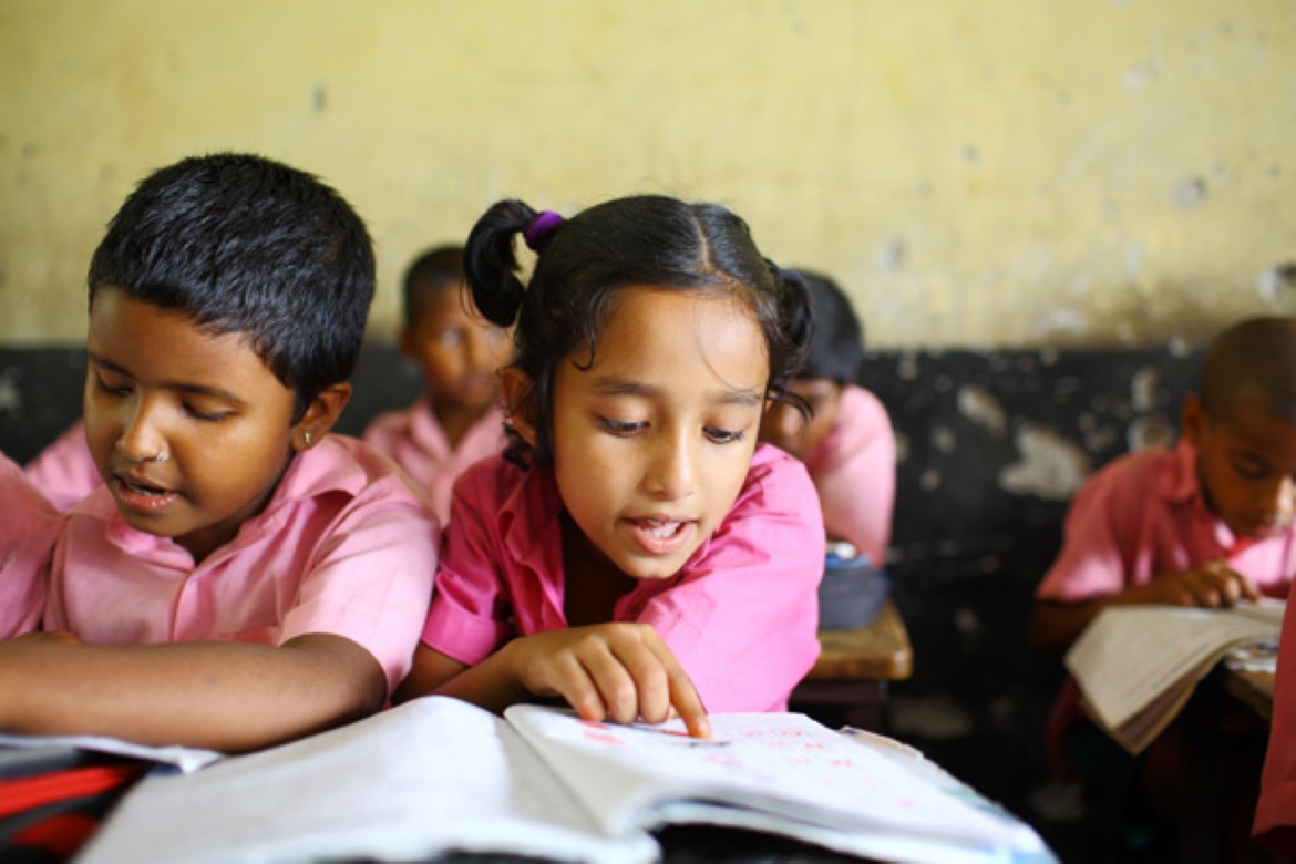 To jenter leser i en bok i et klasserom i Banglasdeh