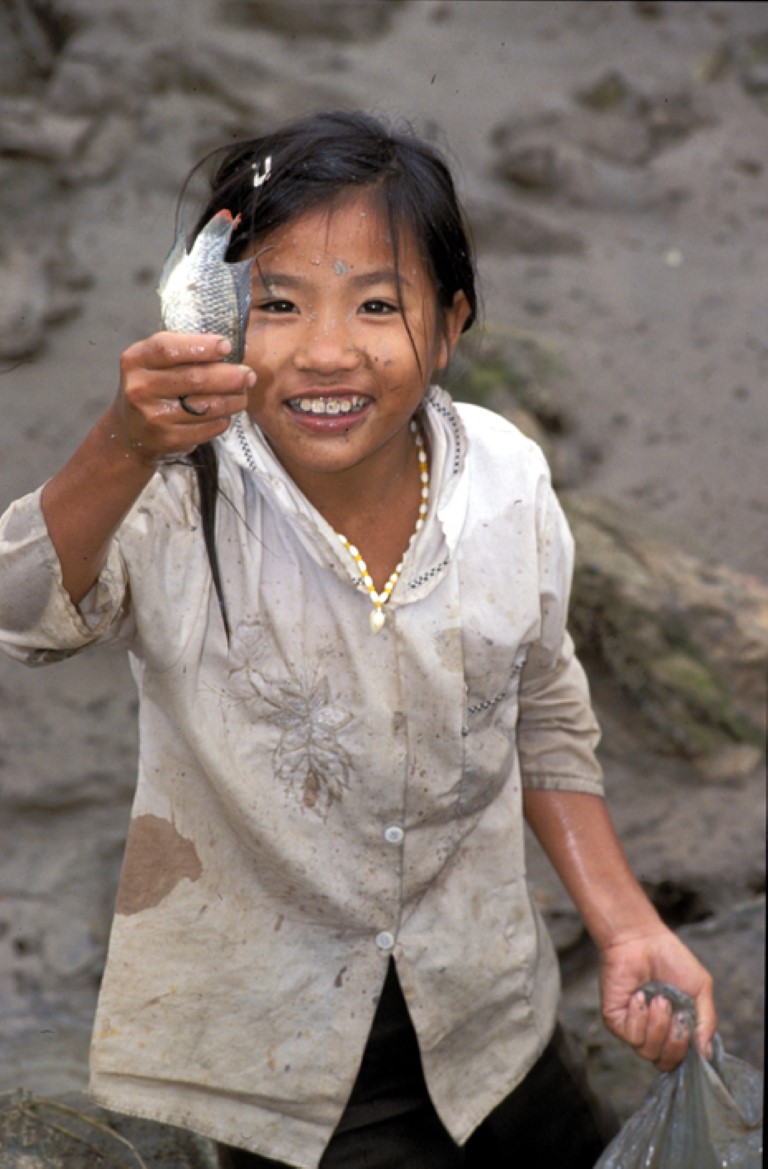 Jente med fisk i hånda. Vietnam.